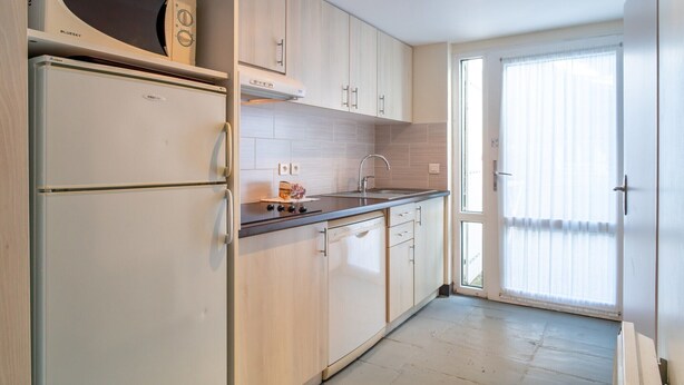 Una cocina moderna con microondas integrado, refrigerador y lavavajillas.