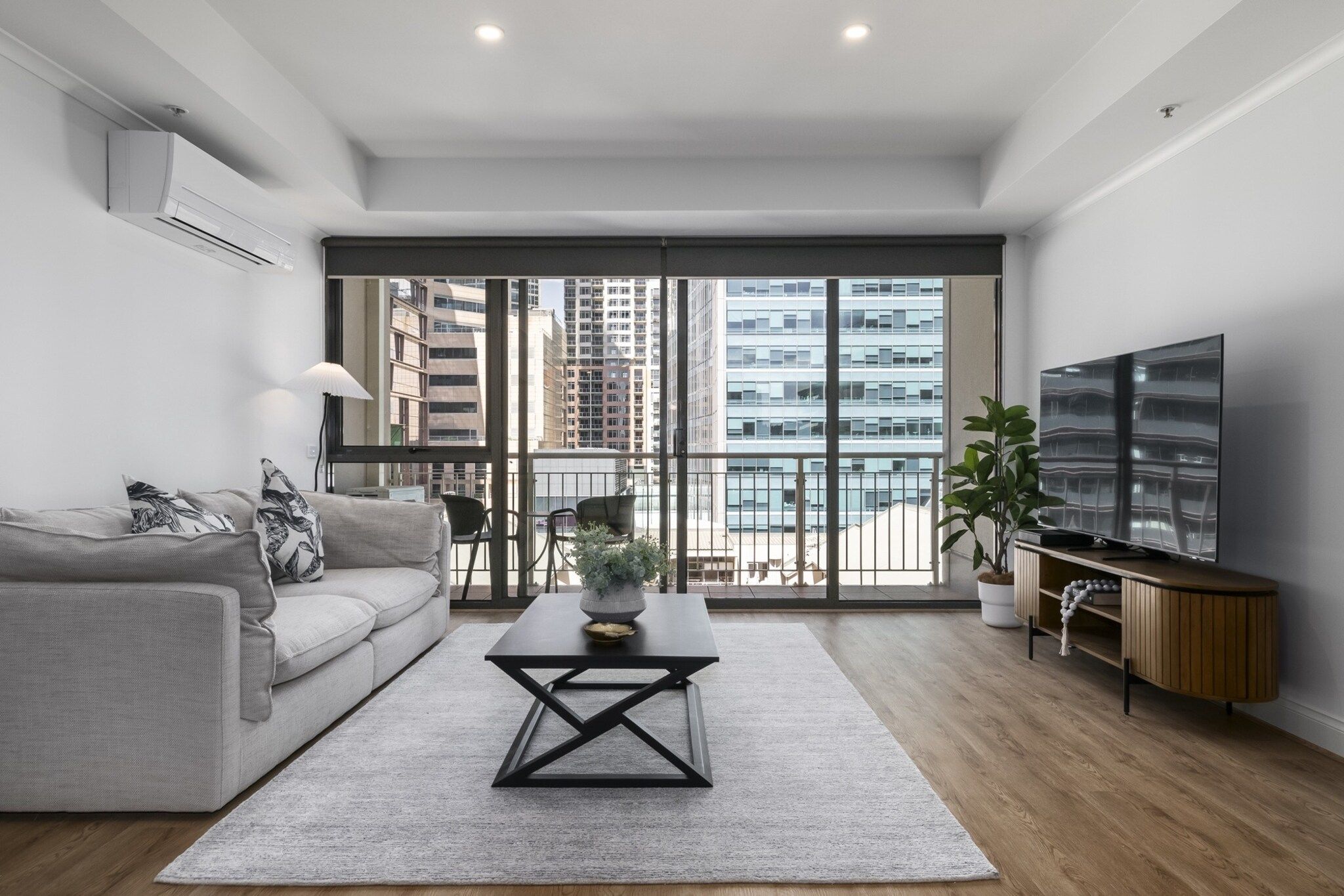 A modern living room with a sofa, coffee table, and a TV.