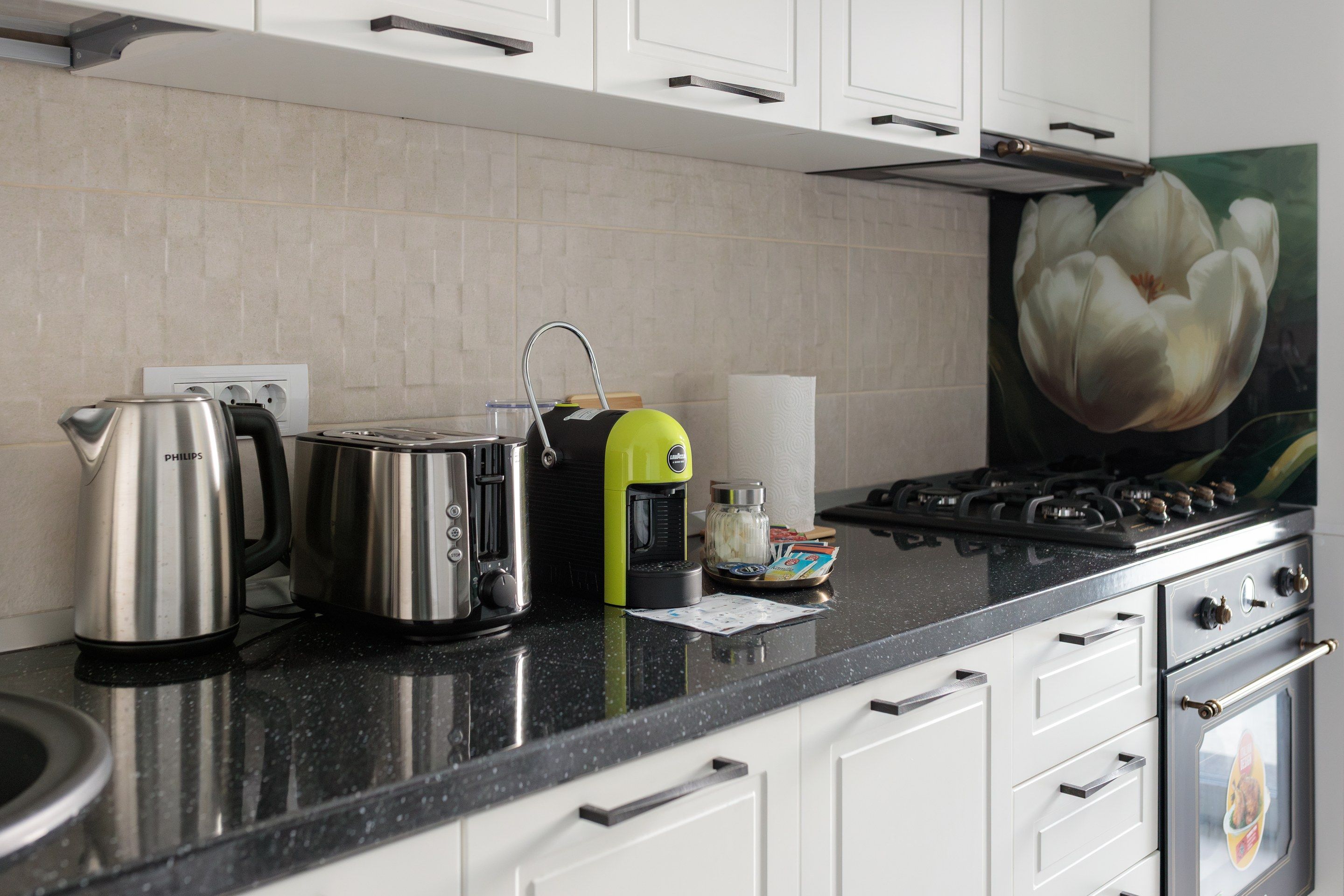 Una cocina equipada con estufa a gas, hervidor, tostadora y cafetera.