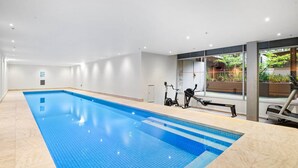 Piscina con equipamiento para ejercicios, vistas a zonas verdes y un diseño interior moderno.