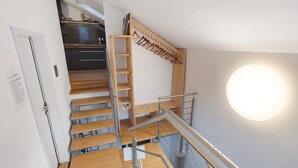 A staircase with wooden steps and metal railings, a wooden coat rack, and a wall-mounted light fixture. - Apartment "Atelier" with Private Terrace and Wi-Fi (Schopfheim)