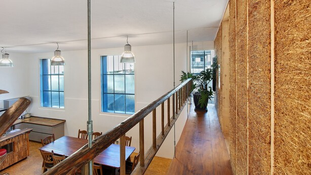 A modern interior with a wooden dining area, a kitchen, and large windows. - Apartment "Atelier" with Private Terrace and Wi-Fi (Schopfheim)