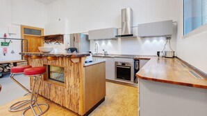 A modern kitchen with a wooden island, stainless steel appliances, and a large window. - Apartment "Atelier" with Private Terrace and Wi-Fi (Schopfheim)