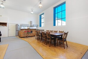 Eine geräumige Küche mit Essbereich, großen Fenstern und moderner Beleuchtung.