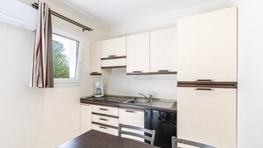 A compact kitchen with white cabinets, a stainless steel sink, and a coffee maker. - Coastal and Garden Living in Corsica (Sari-Solenzara)
