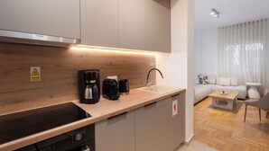 Una cocina moderna con estufa integrada, cafetera y lavabo.