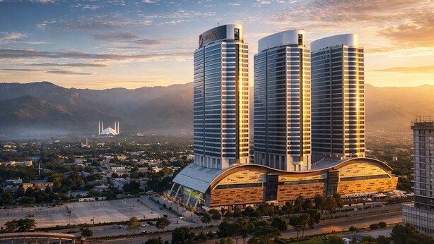 Un edificio moderno con due torri alte, una struttura curva in primo piano e un ponte sullo sfondo.