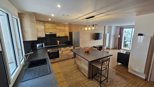 Une cuisine moderne avec des meubles en bois, un îlot central et un coin repas.