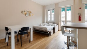 Een slaapkamer met een bed, een bureau en een stoel. Er is een raam met uitzicht op de omgeving.