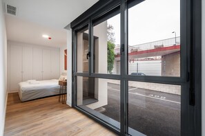 A modern bedroom with a large sliding glass door leading to a parking area. - The Kings Residence: Business Ready alquiler temporal (San Sebastián de los Reyes)