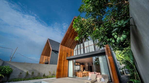 A modern house with a pool, wooden exterior, and a dining area visible through large glass doors. - Keluoli villas Bingin (Pecatu)