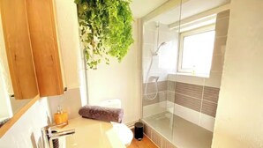 Une salle de bain avec une douche à parois de verre, un lavabo et des toilettes.