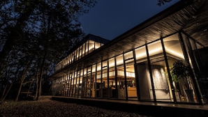 A modern building with large glass windows and a wooden facade at night. - Mengxi Bieyuan Forest Resort Hotel (Huangshan)