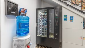 En vattenautomat, en återvinningsbehållare och en varuautomat i en korridor.