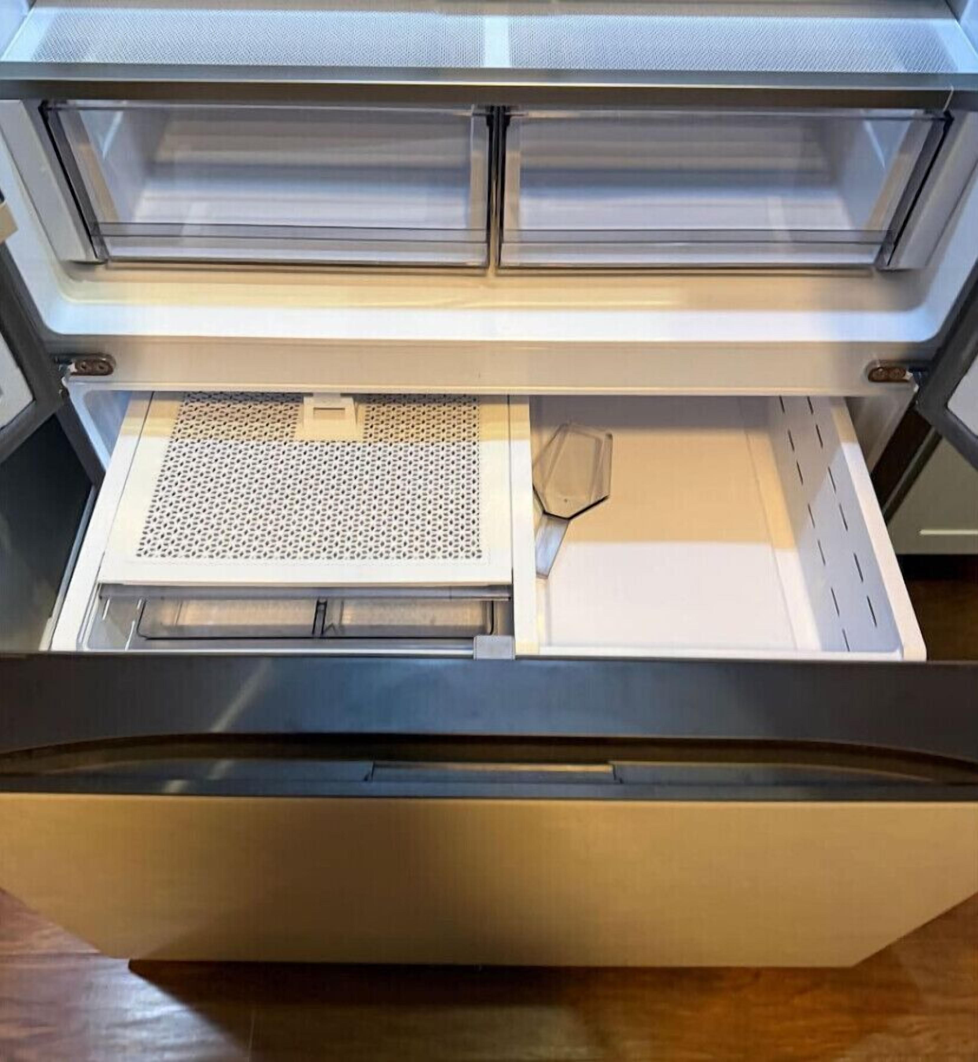Un cassetto con un vassoio forato e una spatola all'interno.