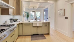 Una cucina moderna con isola centrale, mobili integrati e un'ampia finestra che offre luce naturale.