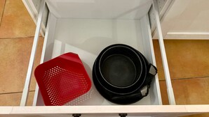 En vit låda med en svart kruka och en röd korg inuti.