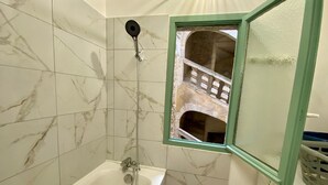 Ett badrum med badkar, dusch och tvättmaskin.