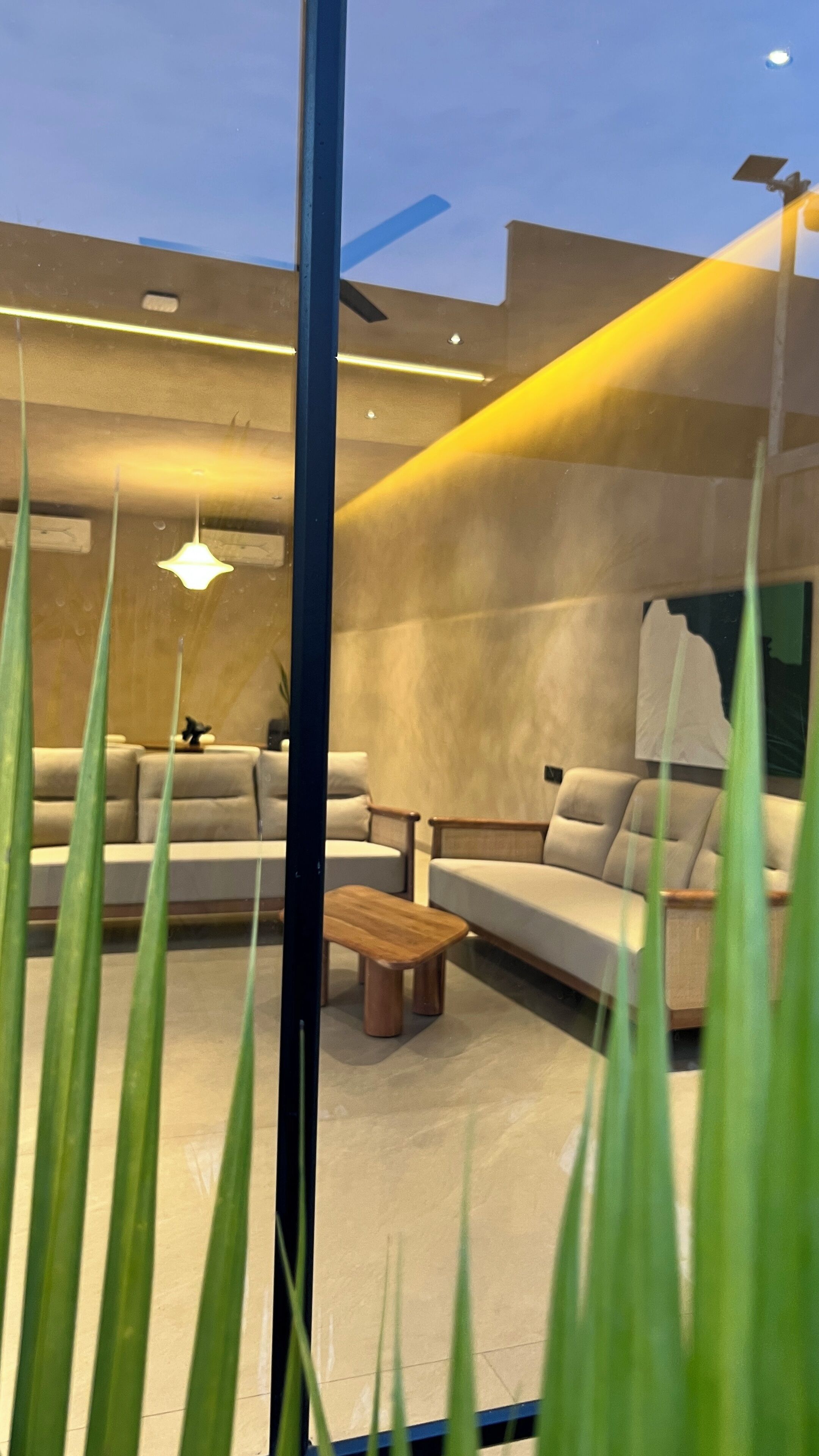Un salon moderne avec un canapé, une table basse et un luminaire suspendu.