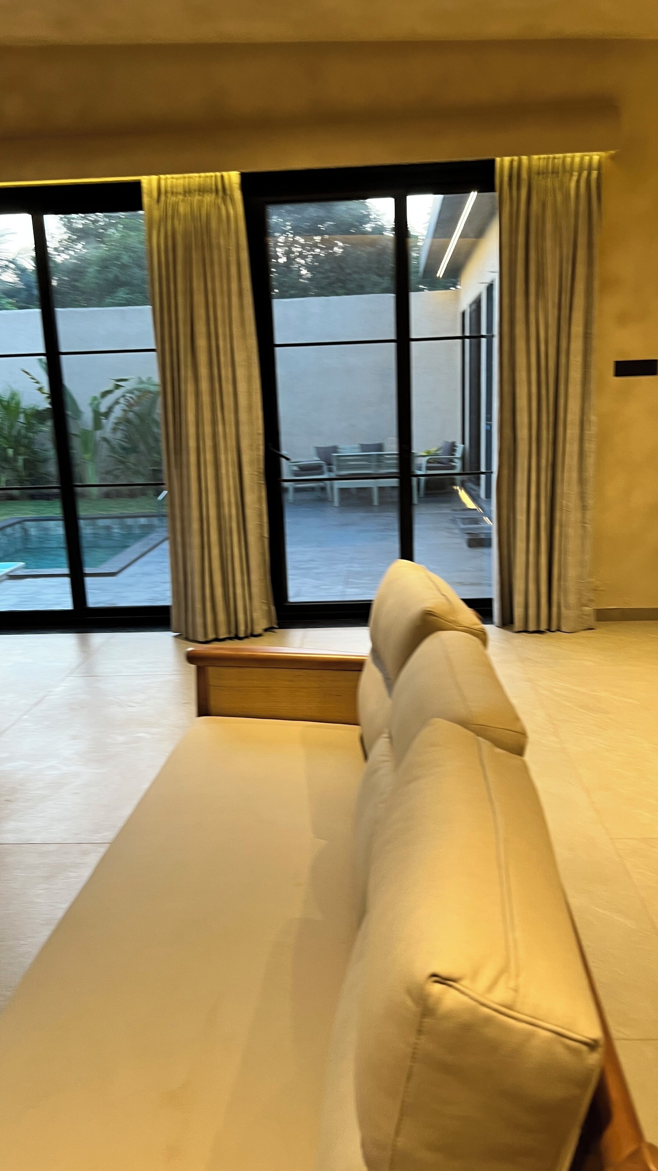 Une chambre moderne dotée d’une grande fenêtre, d’un canapé et offrant une vue sur le mobilier d’extérieur.