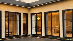 Una casa moderna con piscina, puertas correderas de vidrio y césped cuidado.