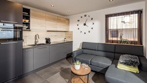 Eine moderne Küche mit grauen Schränken, einer Holz Arbeitsplatte und einem eingebauten Backofen.