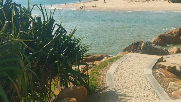 A beach with clear water, a sandy shore, and a path leading to the water. - HESPS OF BEDS (South West Rocks)