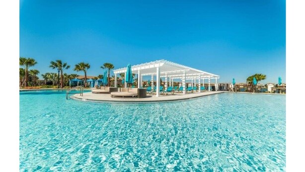 A clear blue pool with a white gazebo and lounge chairs, surrounded by palm trees. - Spacious 7 BR Villa with Pool, Spa, Themed Rooms (Kissimmee)