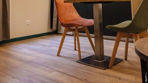 Una cucina moderna con mobili scuri, travi a vista in legno e una finestra con tende.