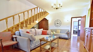 A living room with a staircase, two sofas, a coffee table, and a wooden cabinet. - Two-story holiday home for in Valica (Valica)
