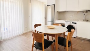 A modern kitchen with white cabinets, a stainless steel refrigerator, and a built-in washing machine. - Rabumba - Aveiro Central Lodging (Aveiro)
