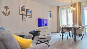 Un soggiorno moderno con divano, tavolo da pranzo e televisione.