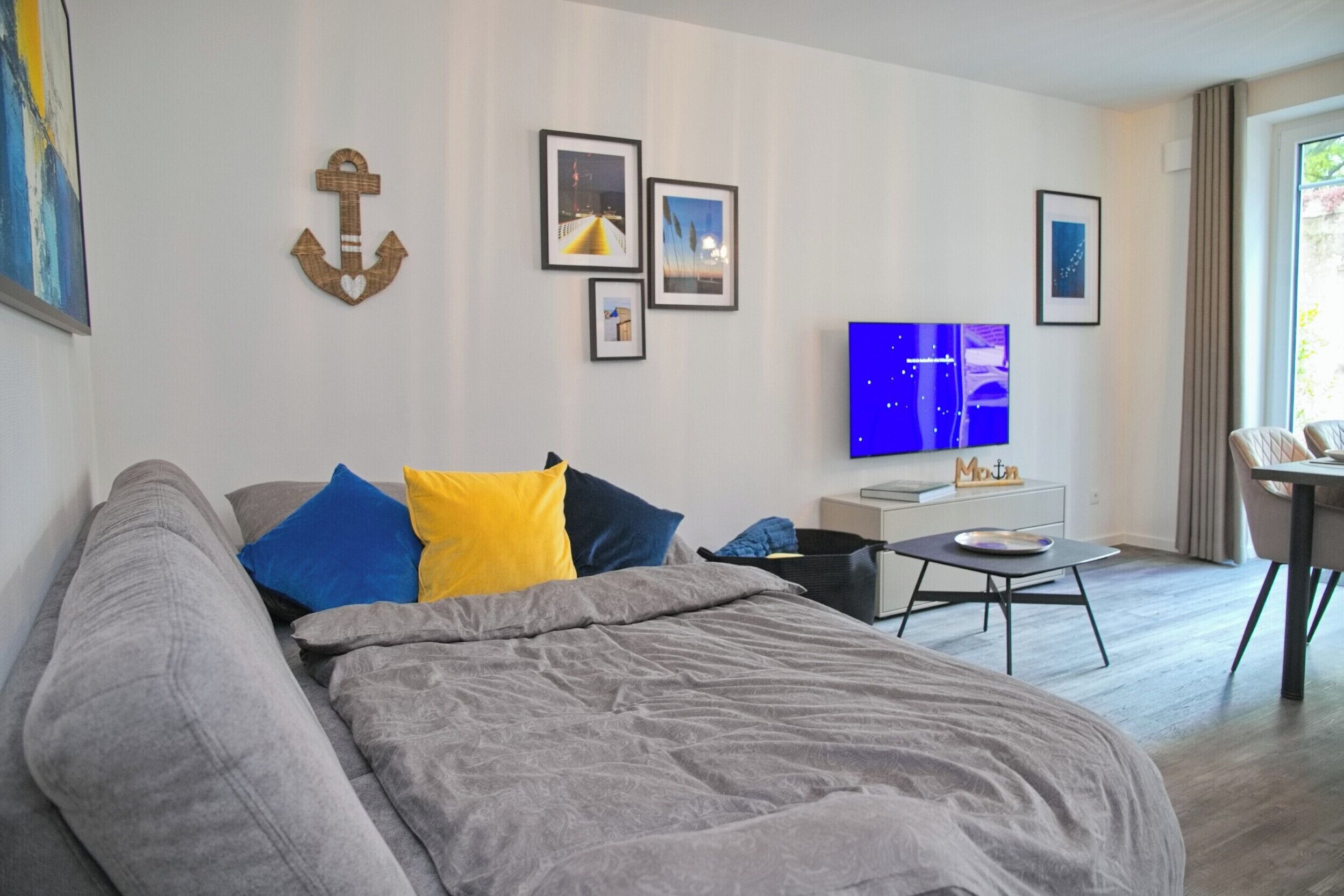 Een moderne hotelkamer met een bed, een televisie, een tafeltje en een stoel.