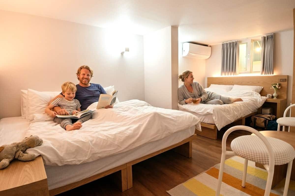 Habitació d'hotel amb dos llits, una taula petita i una cadira.