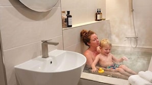 Un baño con un lavamanos grande, ducha y bañera.