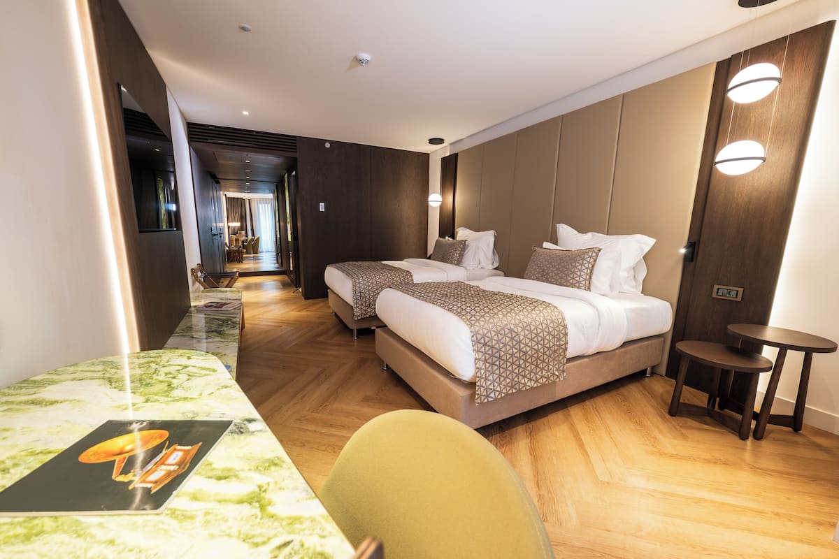 A modern hotel room with a large bed, a small table, and a seating area.