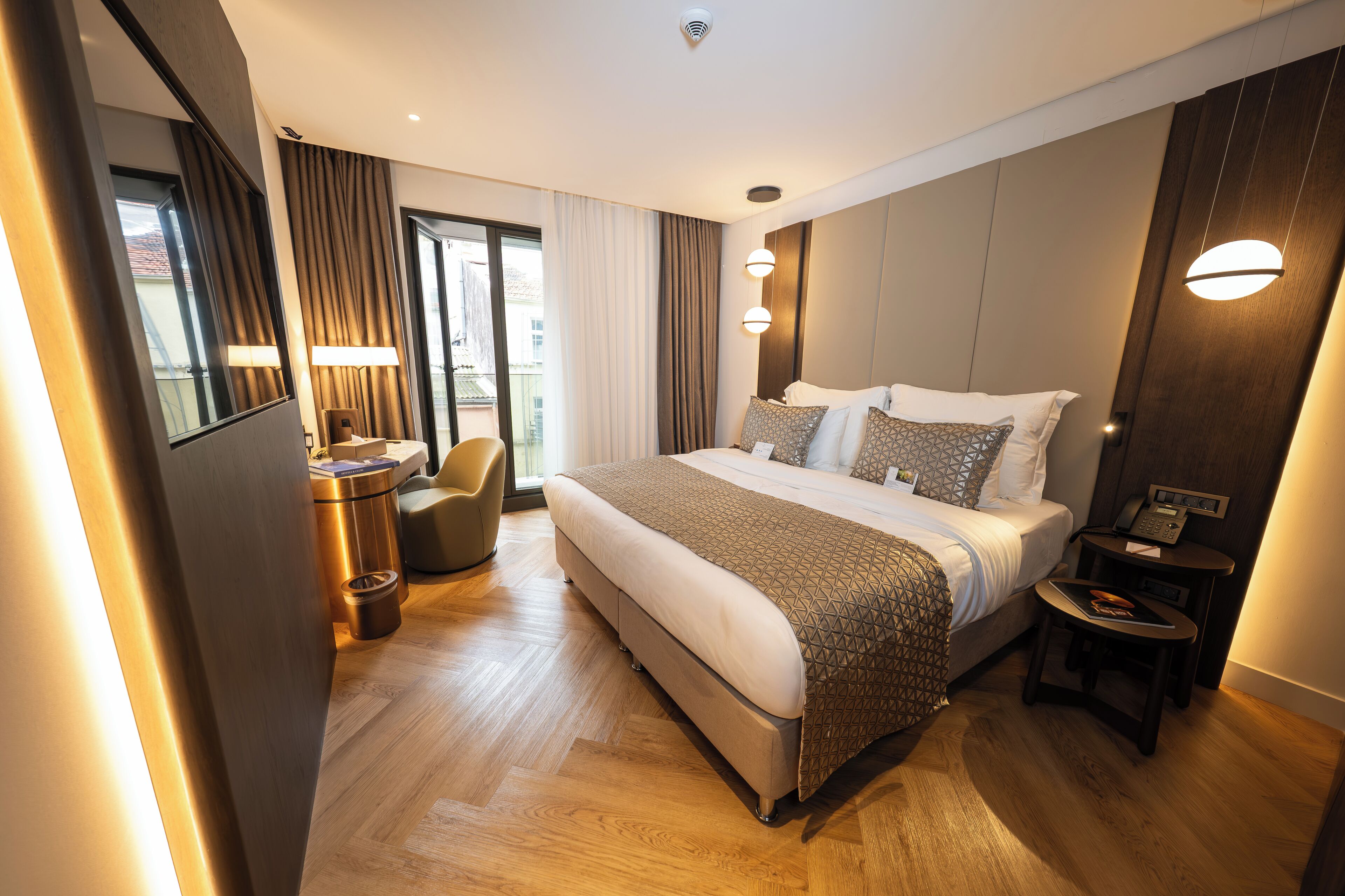 Et moderne hotelværelse med en stor seng, et skrivebord og en stol.