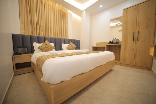 A modern bedroom with a large bed, wooden headboard, and a wardrobe. - BABA PALACE (Ayodhya)