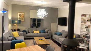 Un salon moderne avec deux canapés gris, une table basse en bois et une cheminée noire.