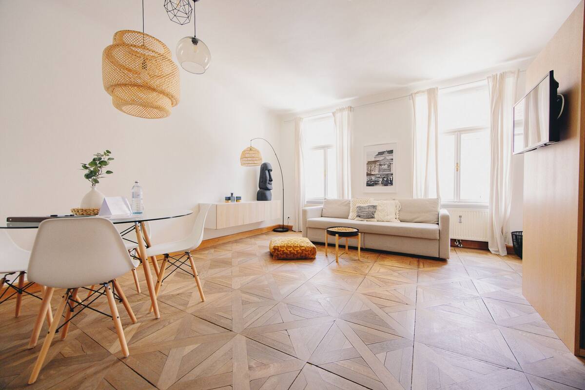 Een moderne woonkamer met een bank, salontafel en een eethoek met stoelen en een tafel.