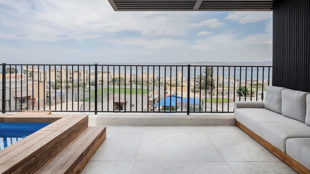 A balcony with a view of a cityscape, a pool, and a sofa. - Artemis  Luxury Apartment with Private Pool and Stunning Views in Tiberias (Tiberias)