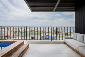 Un balcon avec vue sur le paysage urbain, une piscine et un canapé.