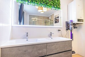 Eenvoudig appartement | Badkamer | Een douche, gratis toiletartikelen, een haardroger, handdoeken