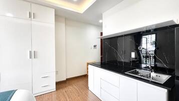 Una cocina moderna con armarios blancos, encimera negra y estufa integrada.