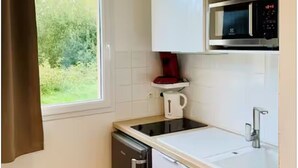 A compact kitchen with a microwave, coffee maker, and dishwasher. - Modern studio with terrace 5 min from Honfleur parking and swimming pool (Équemauville)