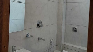 A modern bathroom with a shower, sink, and toilet. - Hotel Gurukripa (Ujjain)