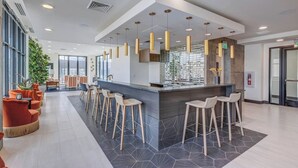 A modern bar area with a central counter, multiple bar stools, and pendant lighting. - 8thFloor!|CityView|HotTub|Pool|Gym|Parking|KingBed (Salt Lake City)