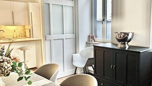 A modern kitchen with white cabinets, a black countertop, and a window with a view. - Spacious 3-bedroom apartment in the heart of Brussels for 8 people (Bruxelles)