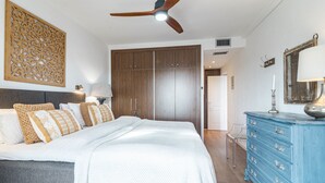 A bedroom with a bed, a ceiling fan, a wardrobe, a dresser, and a decorative wall panel. - MA - Elegant Apartment With Sea Views (Marbella)