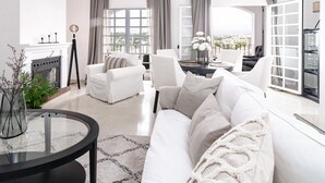 A modern living room with a white sofa, a glass coffee table, and a fireplace. - Ap128 - Big Townhouse - Sunny Side of Aloha Pueblo (Marbella)